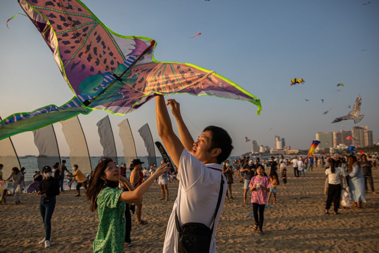 Families fly kites on a beach during a kite festival in Pattaya, Thailand, on Sunday, February 26.