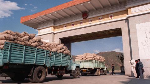 North Korean trucks loaded with sacks of maize wait for clearance at the Chinese border in 1997, during the famine period known as the 