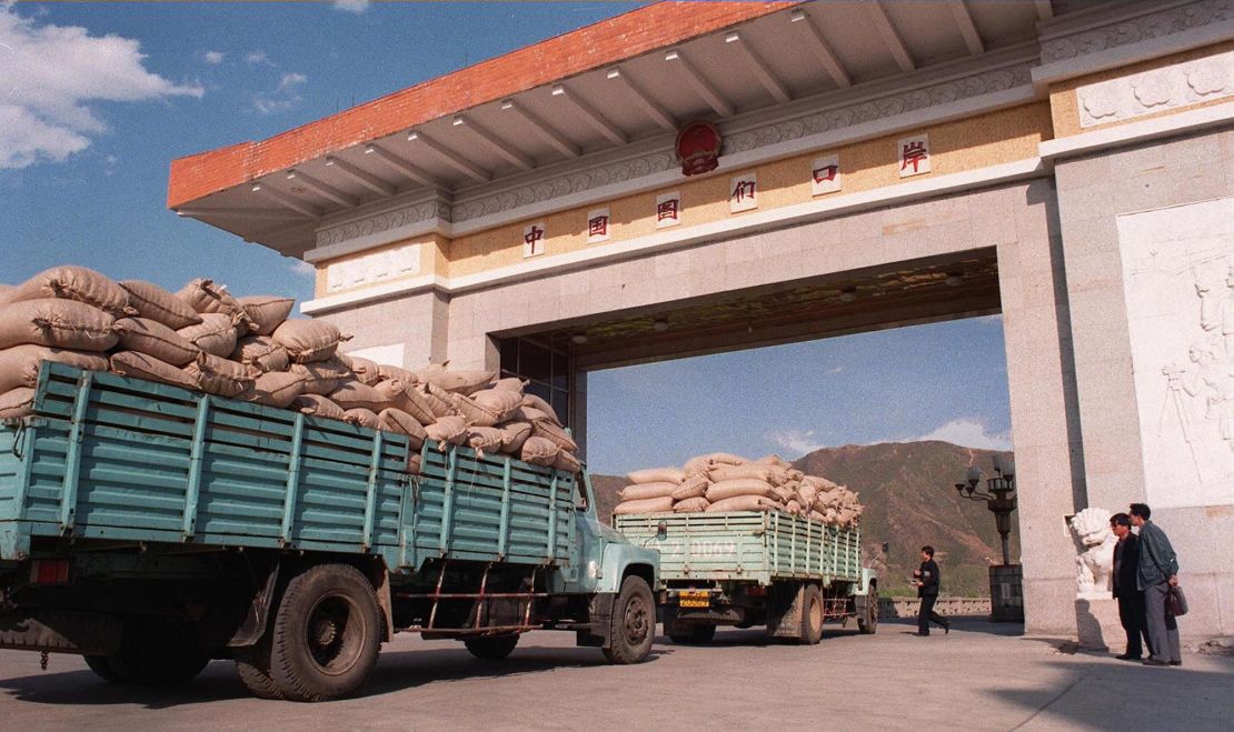 North Korean trucks loaded with sacks of maize wait for clearance at the Chinese border in 1997, during the famine period known as the "Arduous March."