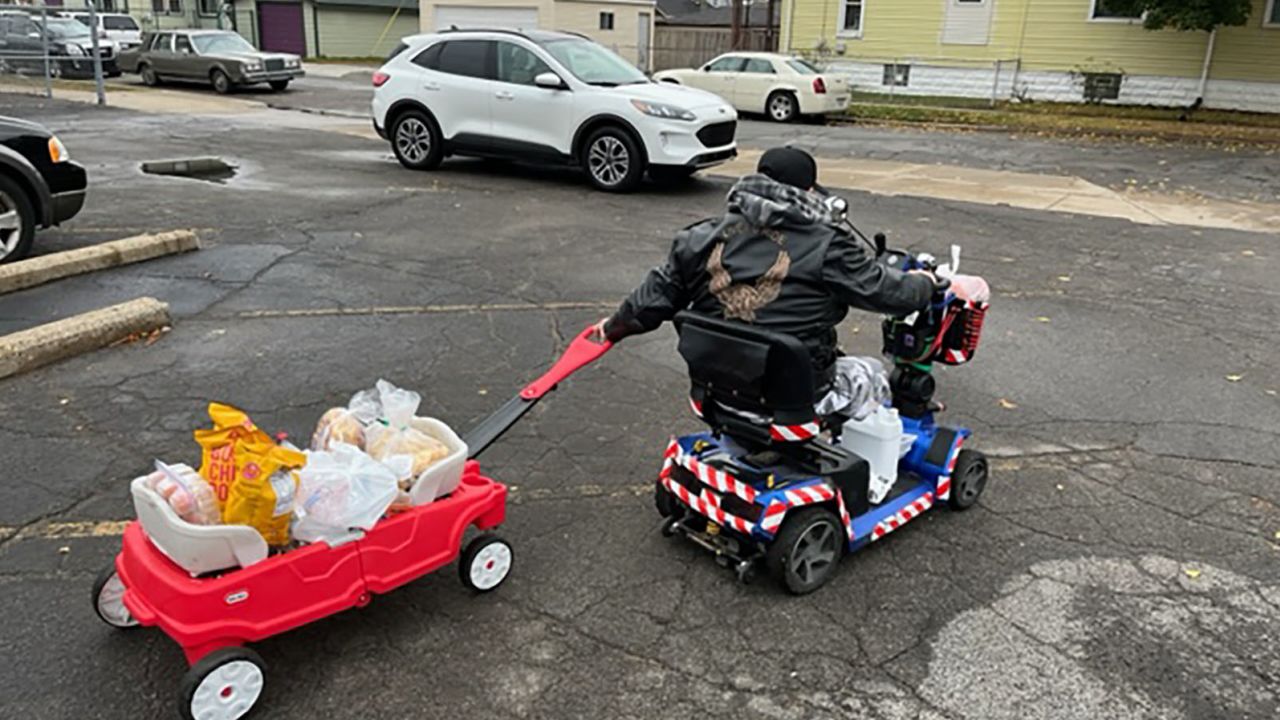 River Rouge, Michigan resident in wheel chair pulls a wagon full of groceries from the school district's "Pantry of Hope" weekly food drive.