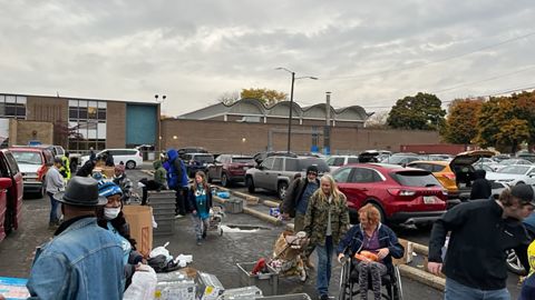 Penduduk setempat telah datang ke drive makanan keliling River Rouge, Michigan ini dengan berjalan kaki dan bahkan melalui kursi roda untuk mengambil makanan setiap minggu.