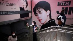 A fan of K-pop boy band BTS takes a selfie in front of an advertisement promoting their concert at Seoul Olympic stadium in Seoul, South Korea, March 10, 2022. 