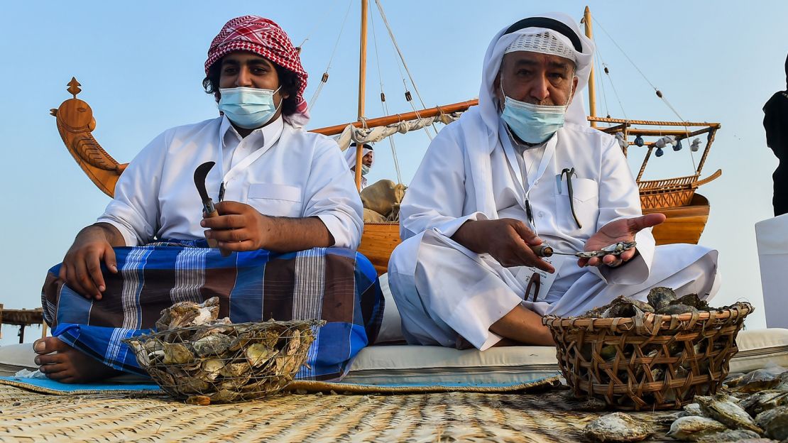 Qatari men open oysters and extract pearls during the Katara Traditional Dhow Festival.