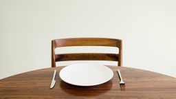 Empty plate with knife and fork on table