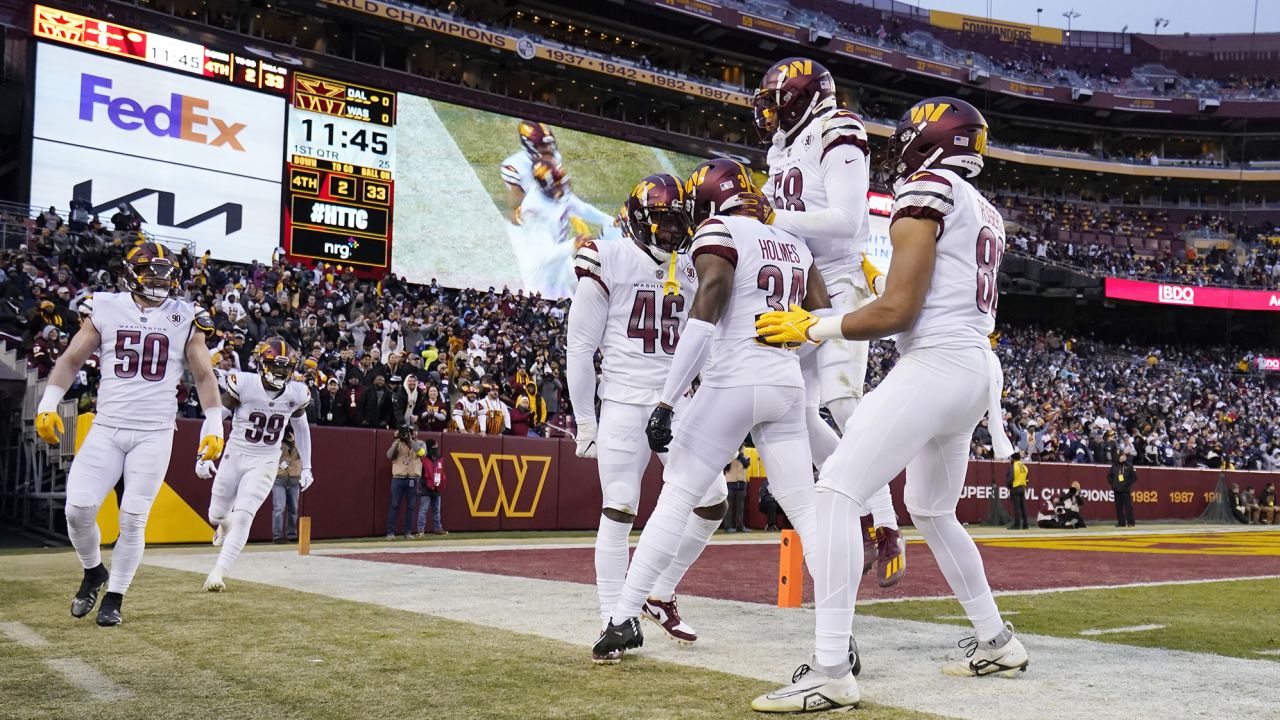 The Washington Commanders celebrate after Milo Eifler completes a play during the first half of the game against the Dallas Cowboys at FedExField on January 8, 2023.