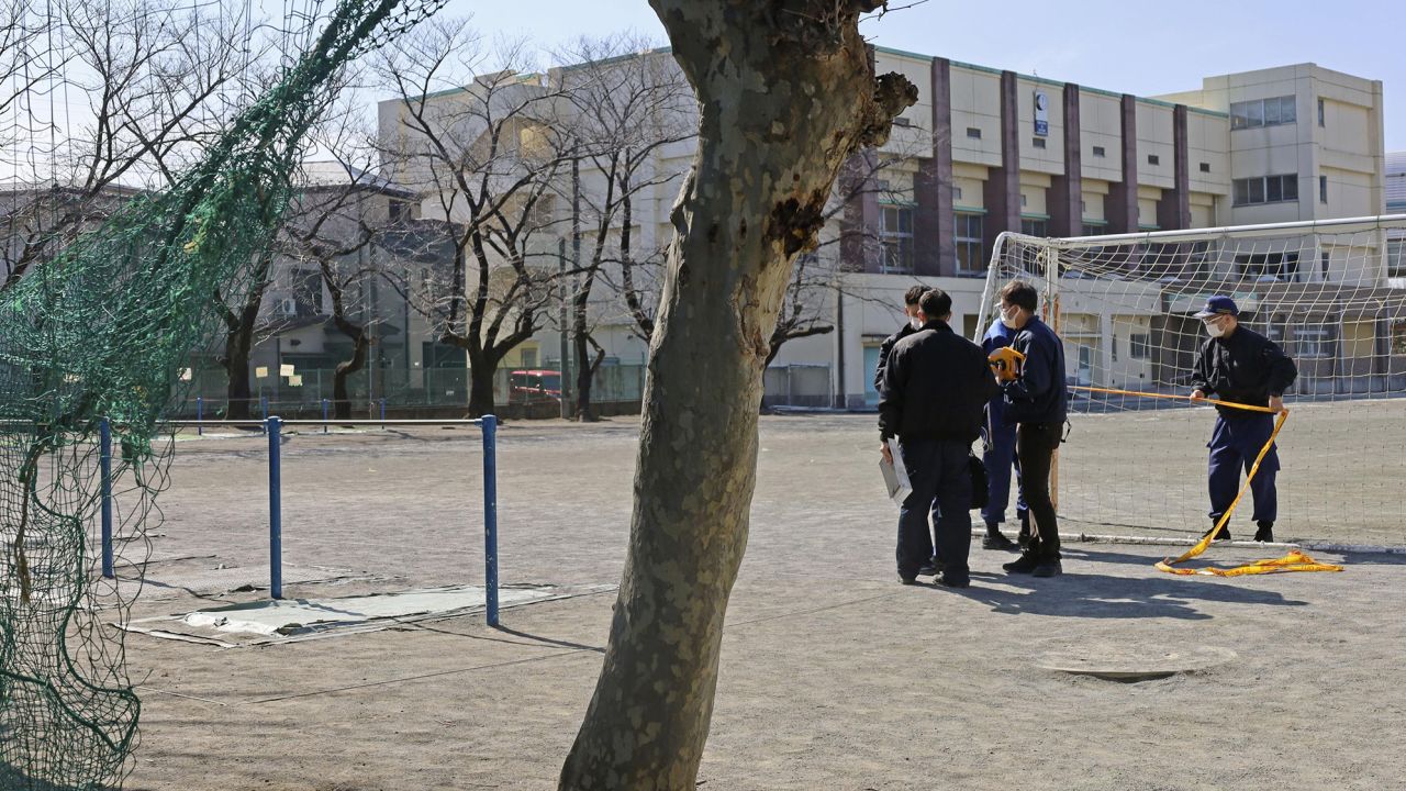 Police investigate an elementary schoolyard in the city of Saitama, near Tokyo, where the body of a cat was found in late February. 