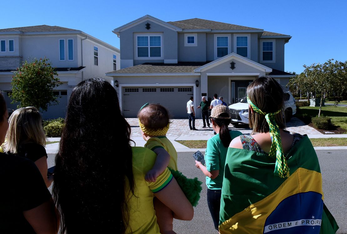 Supporters of Bolsonaro stand in front of the home he is staying in, hoping he will emerge, in Kissimmee, Florida.