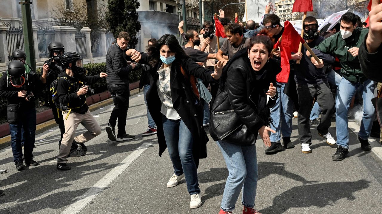TOPSHOT - Protesters shout towards gas-throwing riot police during a massive demonstration in Athens on March 5, 2023, following the deadly train accident late on February 28. 