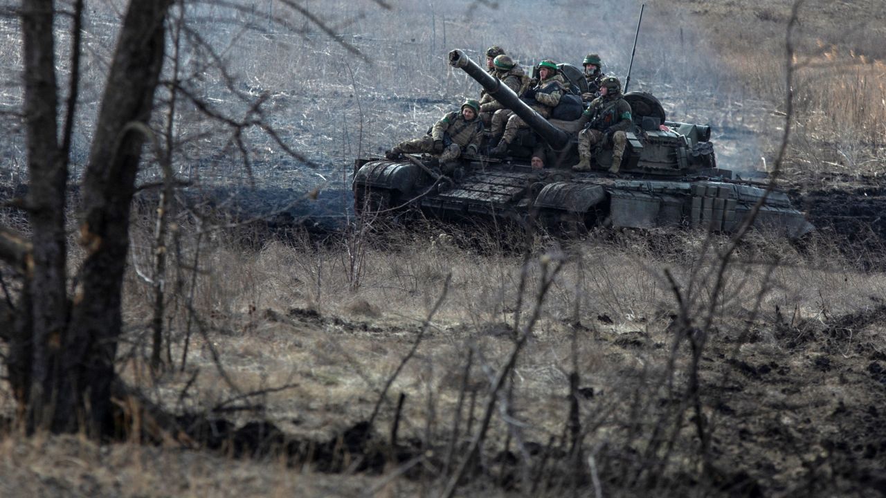 Ukrainian service members ride atop of a tank outside  Bakhmut, on March 4, 2023. 