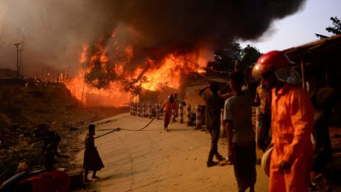 Rohingya refugees try to douse the devastating fire that has left around 12,000 people homeless.