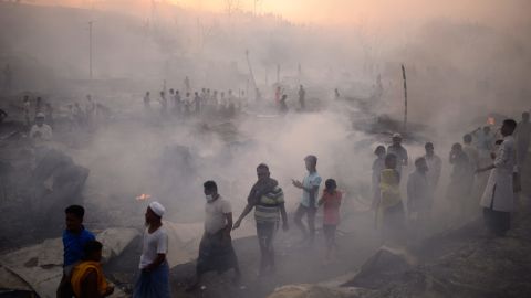 Rohingya refugees try to save their belongings after the big fire has destroyed the camp.