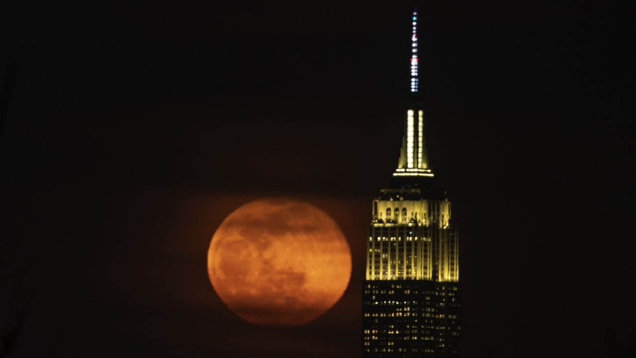 The full worm moon rises behind the Empire State Building in Manhattan on March 18, 2022. 