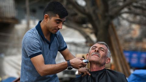 Ziya Sutdelisi, 53, a former local administrator, receives a free haircut from a volunteer from Gaziantep, in the village of Buyuknacar, near Pazarcik, Kahramanmaras province on Sunday, one month after a massive earthquake struck southeast Turkey.