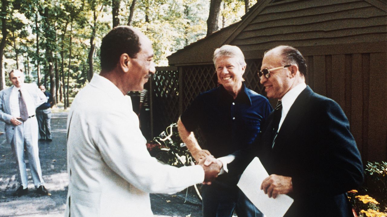 Egyptian President Anwar al-Sadat shakes hands with Israel Prime Minister Menachem Begin with President Jimmy Carter at Camp David in Maryland on September 6, 1978.