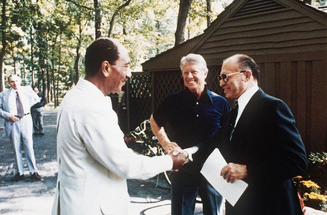 Egyptian President Anwar al-Sadat shakes hands with Israel Prime Minister Menachem Begin with President Jimmy Carter at Camp David in Maryland on September 6, 1978.