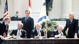 President Jimmy Carter sits between Egyptian President Anwar al-Sadat and Israel Prime Minister Menachem Begin as they sign the historic US-sponsored peace treaty between Israel and Egypt on March 26, 1979 at the White House in Washington, DC.