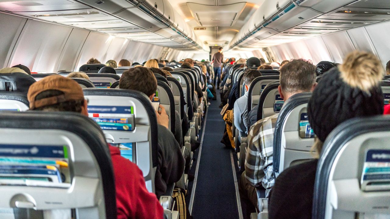 Passengers seated inside an airplane.