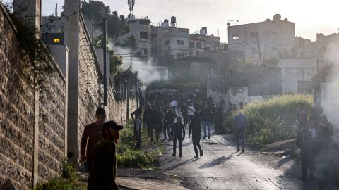 People gather along a road during an Israeli military raid in the Jenin camp for Palestinian refugees in the West Bank on Tuesday. 