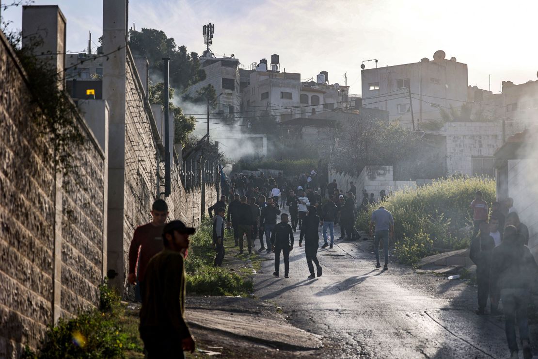 People gather along a road during an Israeli military raid in the Jenin camp for Palestinian refugees in the West Bank on Tuesday. 