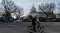 A bicyclist rides past the U.S. Capitol building, surrounded by temporary anti-riot fencing installed around its perimeter, on the day of U.S. President Joe Biden's State of the Union Address to a joint session of Congress on Capitol Hill in Washington, U.S., February 7, 2023. 