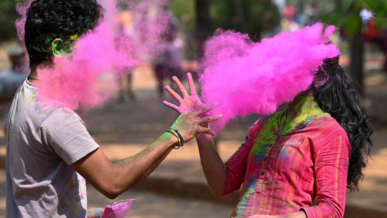 People throw "gulal," or colored powder, as part of Holi celebrations in Hyderabad on March 7, 2023.