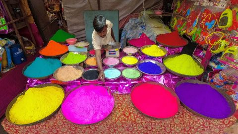 Sprzedawca organizuje sprzedaż kolorowych proszków przed Holi w Kalkucie, Indie, 3 marca 2023 r.