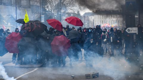 Protesters use umbrellas as protection against tear gas on the sidelines of a demonstration in Nantes, western France on March 7, 2023.