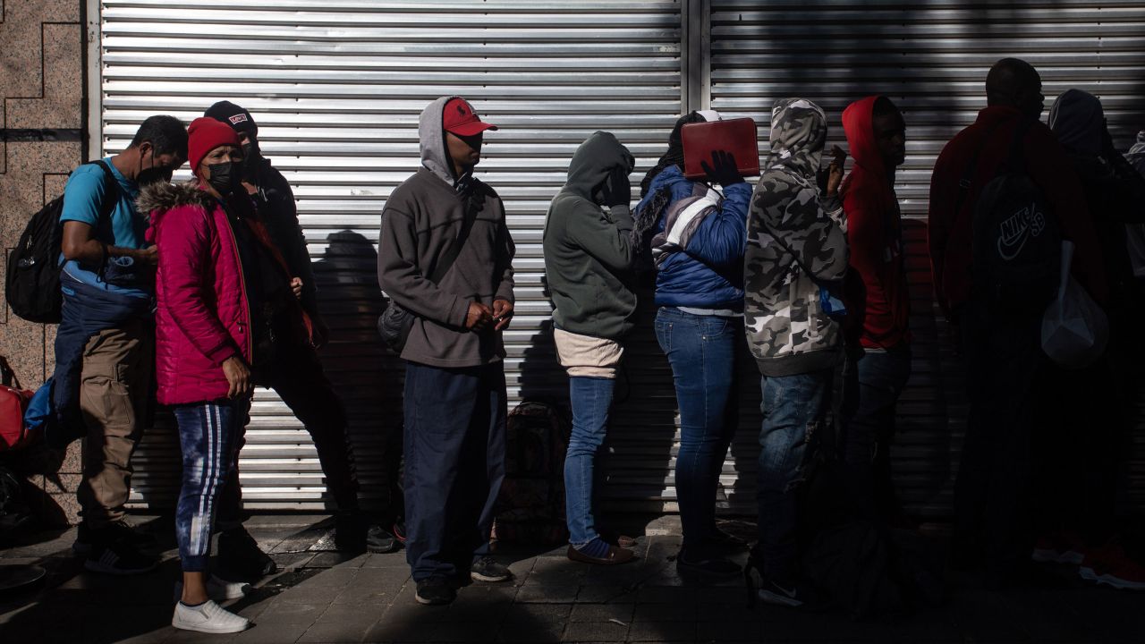 Migrants wait in line outside at the Mexican Commission for Refugee Assistance in Mexico City, Mexico, on January 24, 2023.