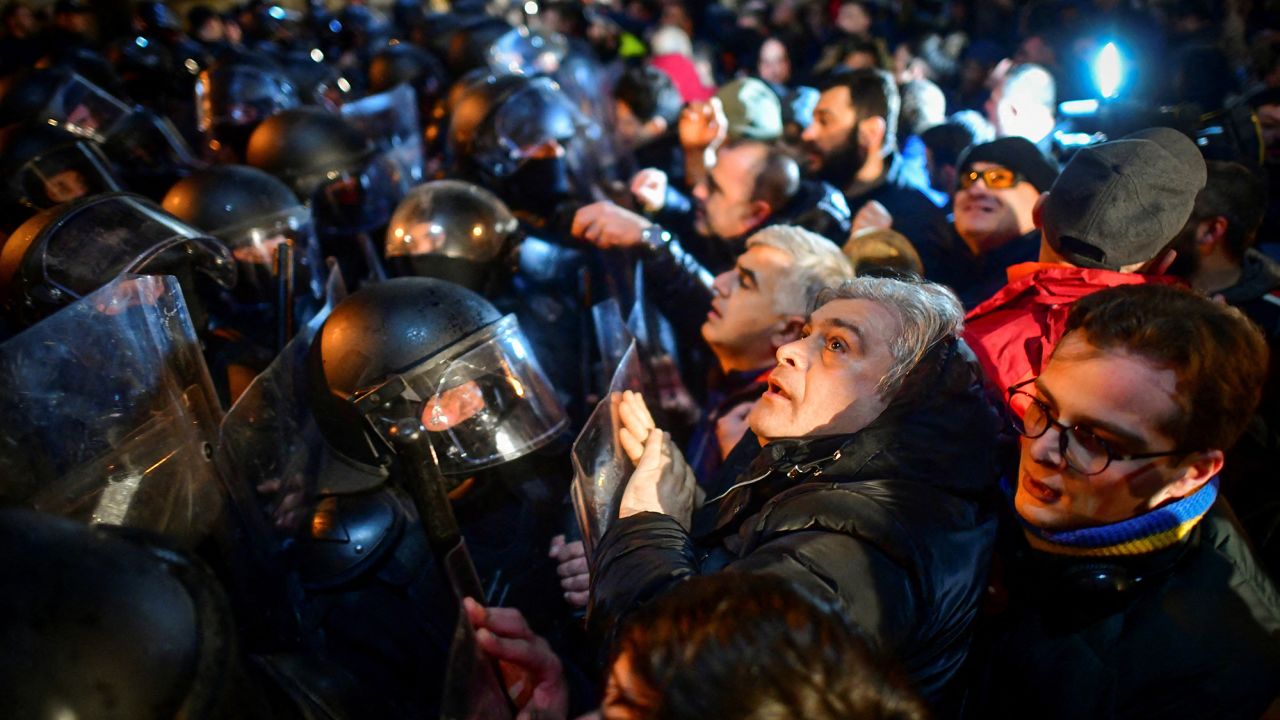 Protesters gather in front of police officers, who block the way during a rally against the "foreign agents" law in Tbilisi, Georgia, March 7, 2023.