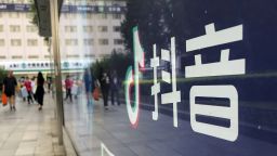 The reflection of pedestrians is seen in a billboard advertising Chinese video app TikTok at Wangfujing street on August 20, 2020 in Beijing, China. 