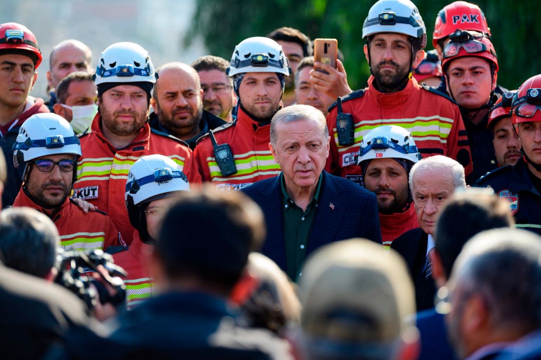 Turkish President Recep Tayyip Erdogan stands with rescue workers as he visits the hard-hit southeastern province of Hatay, the seen of destruction following two earthquakes on February 20, 2023. - A 7.8-magnitude earthquake hit near Gaziantep, Turkey, in the early hours of February 6, followed by another 7.5-magnitude tremor just after midday. The quakes caused widespread destruction in southern Turkey and northern Syria and has killed some 45,000 people. (Photo by Yasin AKGUL / AFP) (Photo by YASIN AKGUL/AFP via Getty Images)