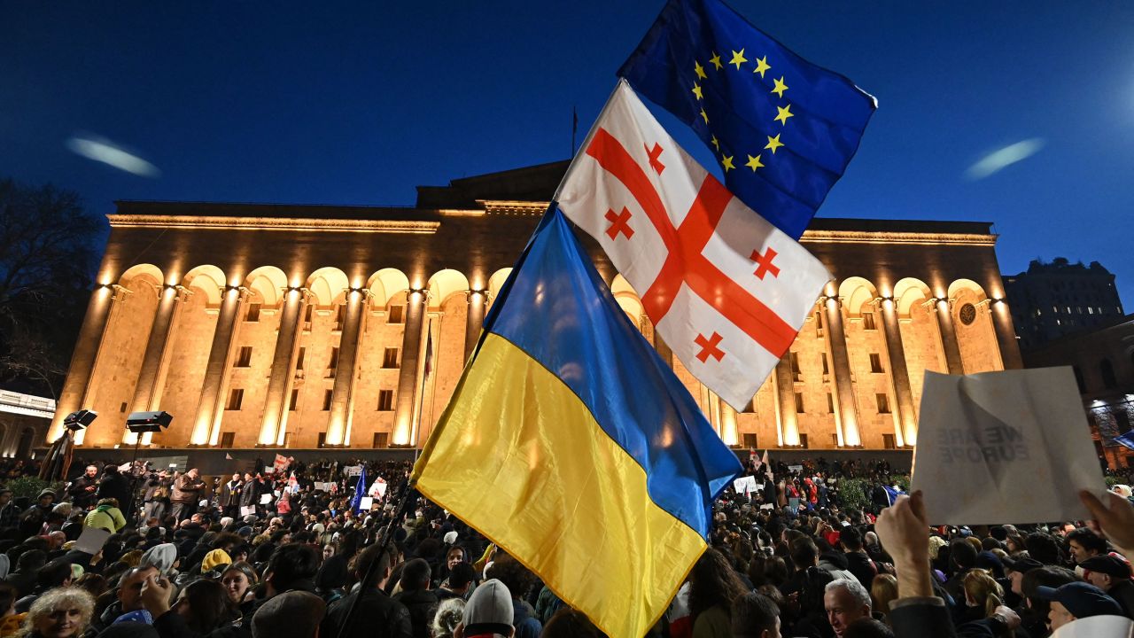 A protesters wave the Georgian, Ukrainian and European flags outside Georgia's Parliament in Tbilisi on March 8, 2023. 