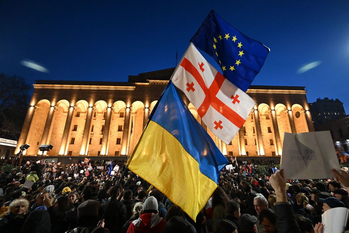 A protesters wave the Georgian, Ukrainian and European flags outside Georgia's Parliament in Tbilisi on March 8, 2023. 