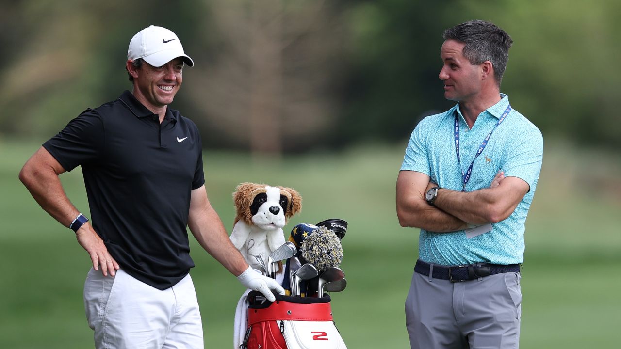 McIlroy chats with his manager Sean O'Flaherty during a practice round ahead of the tournament.