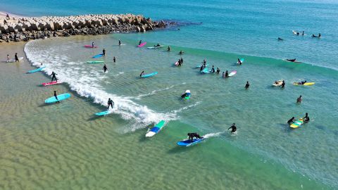 Esta foto aérea muestra a los turistas surfeando en Rewi Bay.