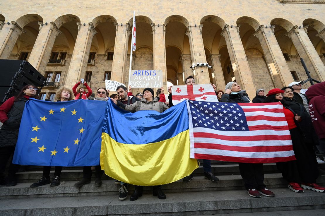 People hold flags of the Europan Union, Ukraine and the USA during a demonstration outside Georgia's Parliament in Tbilisi on March 8, 2023. 