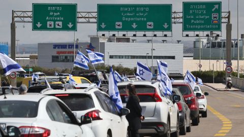 Los automóviles se alinean en la carretera principal que conduce al área de salidas del aeropuerto Ben Gurion en Tel Aviv, Israel, el 9 de marzo de 2023, mientras los manifestantes bloquean la carretera.