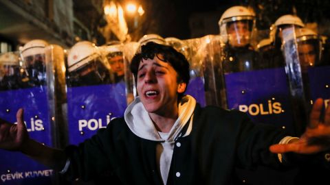 Turkish police stand behind a protester in Istanbul, pictured earlier this week, during a demonstration where parts of the crowd called for the government to resign ahead of a general election.