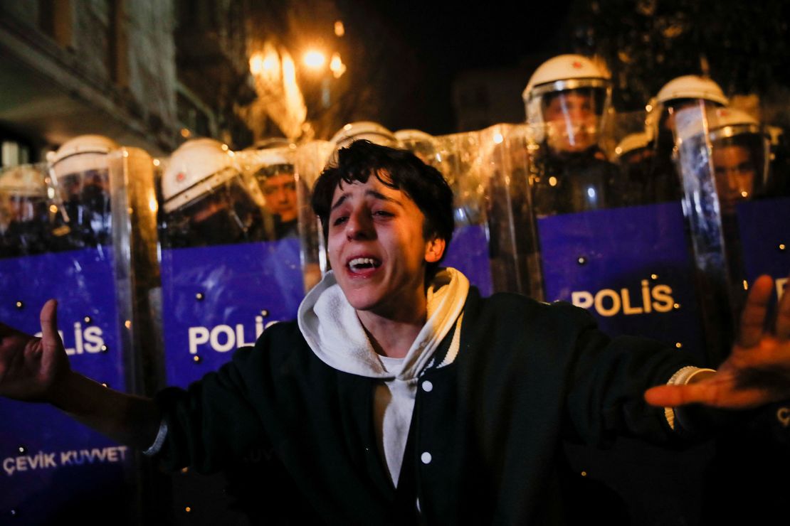 Turkish police stand behind a protester in Istanbul, pictured earlier this week, during a demonstration where parts of the crowd called for the government to resign ahead of a general election.