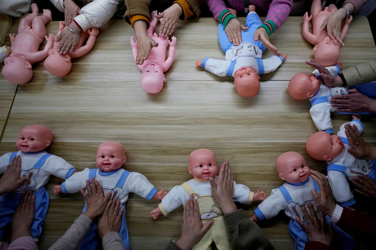 Women train with plastic baby dolls as they take a nursing skills class in Shanghai, China, on Thursday, March 2. The women were learning to be <a href="https://www.reuters.com/world/china/need-nanny-chinese-school-trains-women-take-care-newborns-2023-03-08/" target="_blank" target="_blank">"confinement carers"</a> who look after mothers and their newborn babies.
