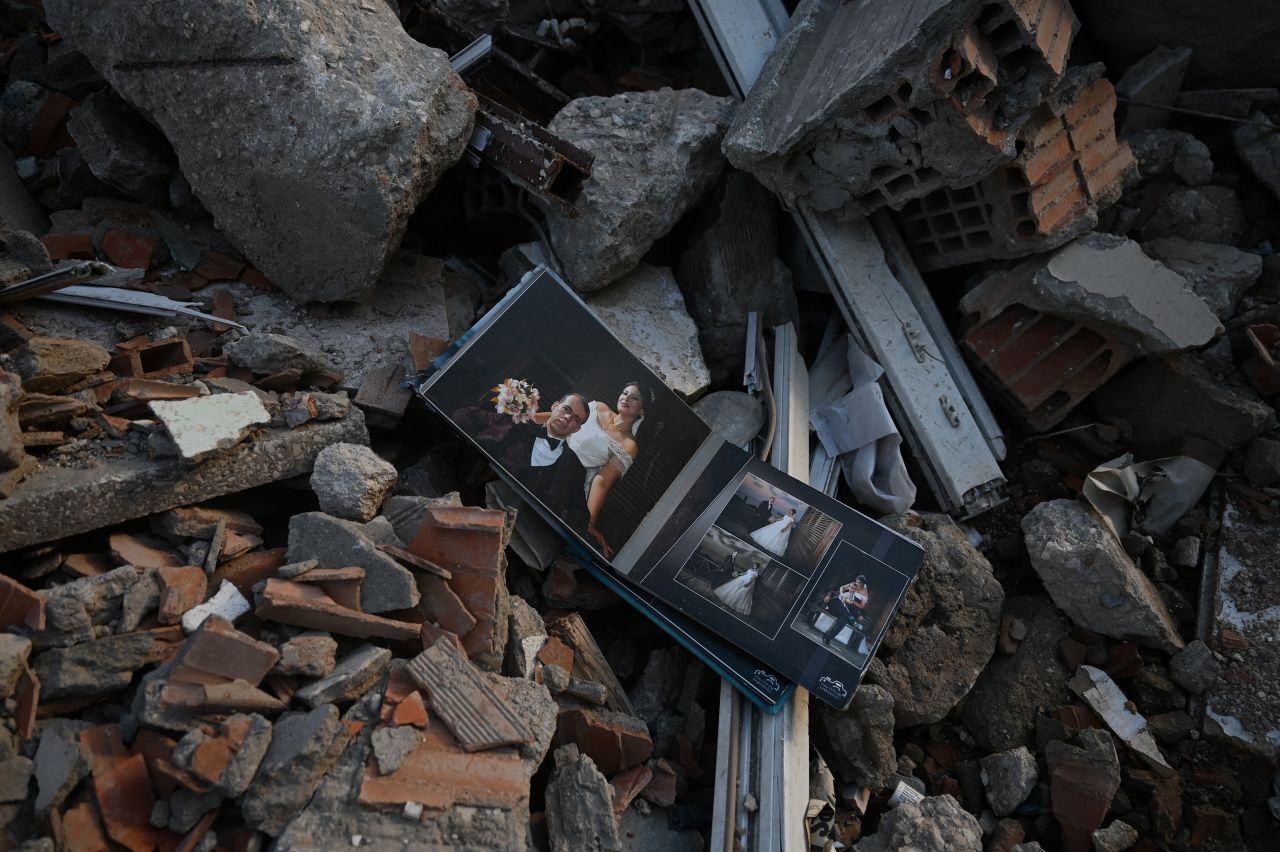 A wedding album is seen among the rubble of a collapsed building in Hatay, Turkey, on Tuesday, March 7. Tens of thousands of people were killed after a <a href=