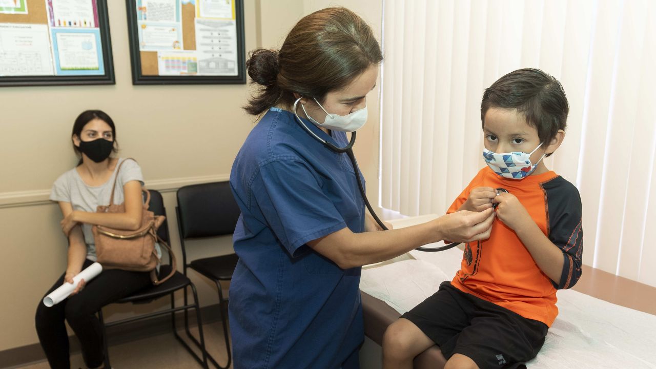 Dr. Kate Williamson listens to a child's heart during a yearly routine exam as his mom watches at Southern Orange County Pediatric Associates in Ladera Ranch, California, in July 2020. 
