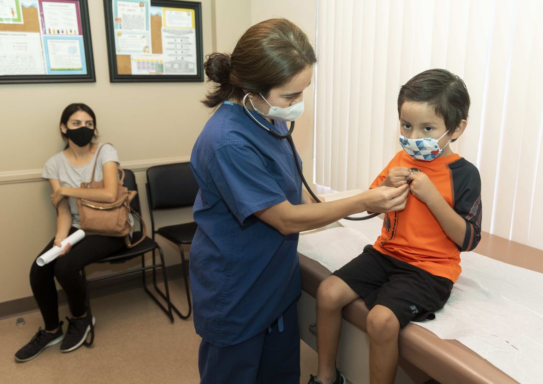 Dr. Kate Williamson listens to a child's heart during a yearly routine exam as his mom watches at Southern Orange County Pediatric Associates in Ladera Ranch, California, in July 2020. 