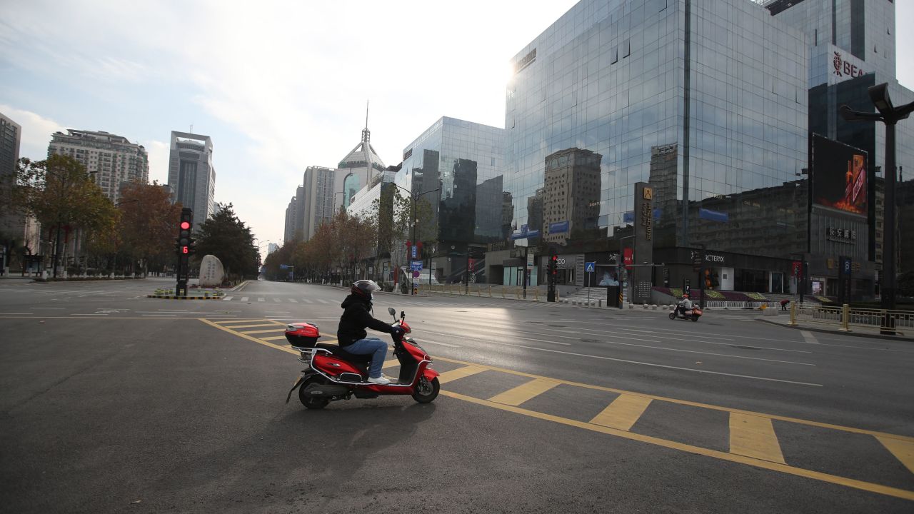 A man rides a scooter on nearly empty roads in Xi'an amid a coronavirus lockdown in 2021