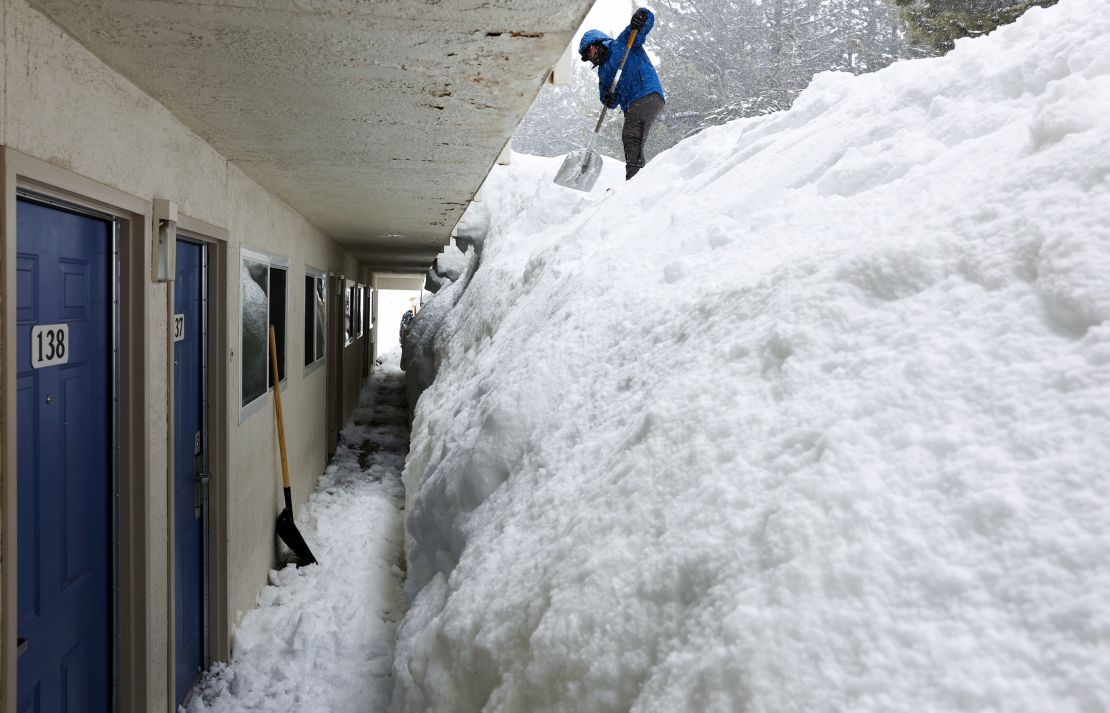 Cristian Nunez shovels a snowbank at a motel on March 11 in Mammoth Lakes, California.