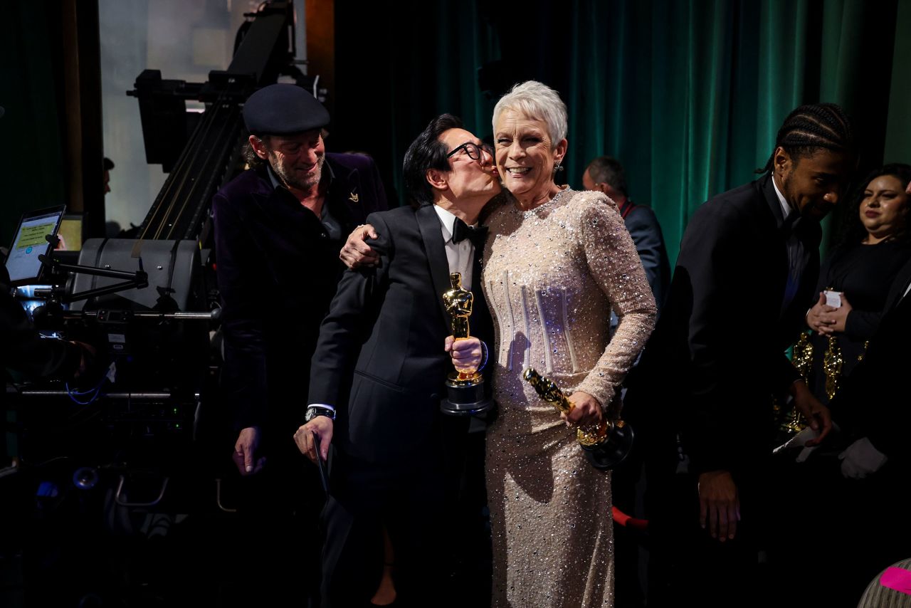 Quan kisses Jamie Lee Curtis backstage. Both won supporting actor Oscars for their roles in 