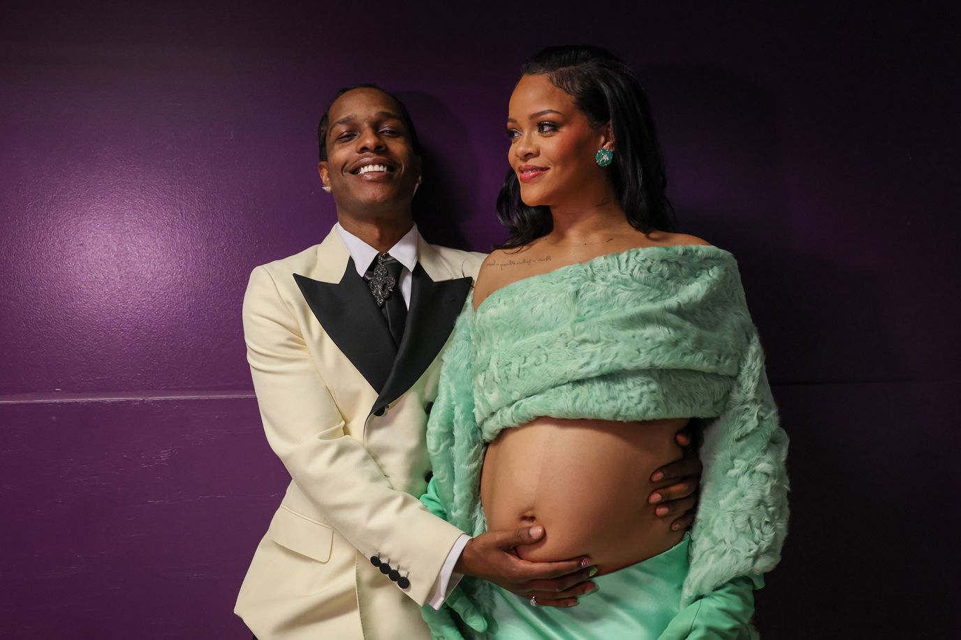 A$AP Rocky puts his hand on Rihanna's belly backstage. The two are expecting their second child together.