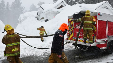 Firefighters from the Mammoth Lakes Fire Department respond to a propane heater leak and a small fire at a closed restaurant surrounded by snowdrifts on March 12, 2023 in Mammoth Lakes, California.