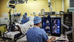 A surgeon sitting in front of screens of a Focal One device performs a robot-assisted prostate tumorectomy using ultrasound imaging on April 10, 2014 at the Edouard Herriot hospital in Lyon, center France.