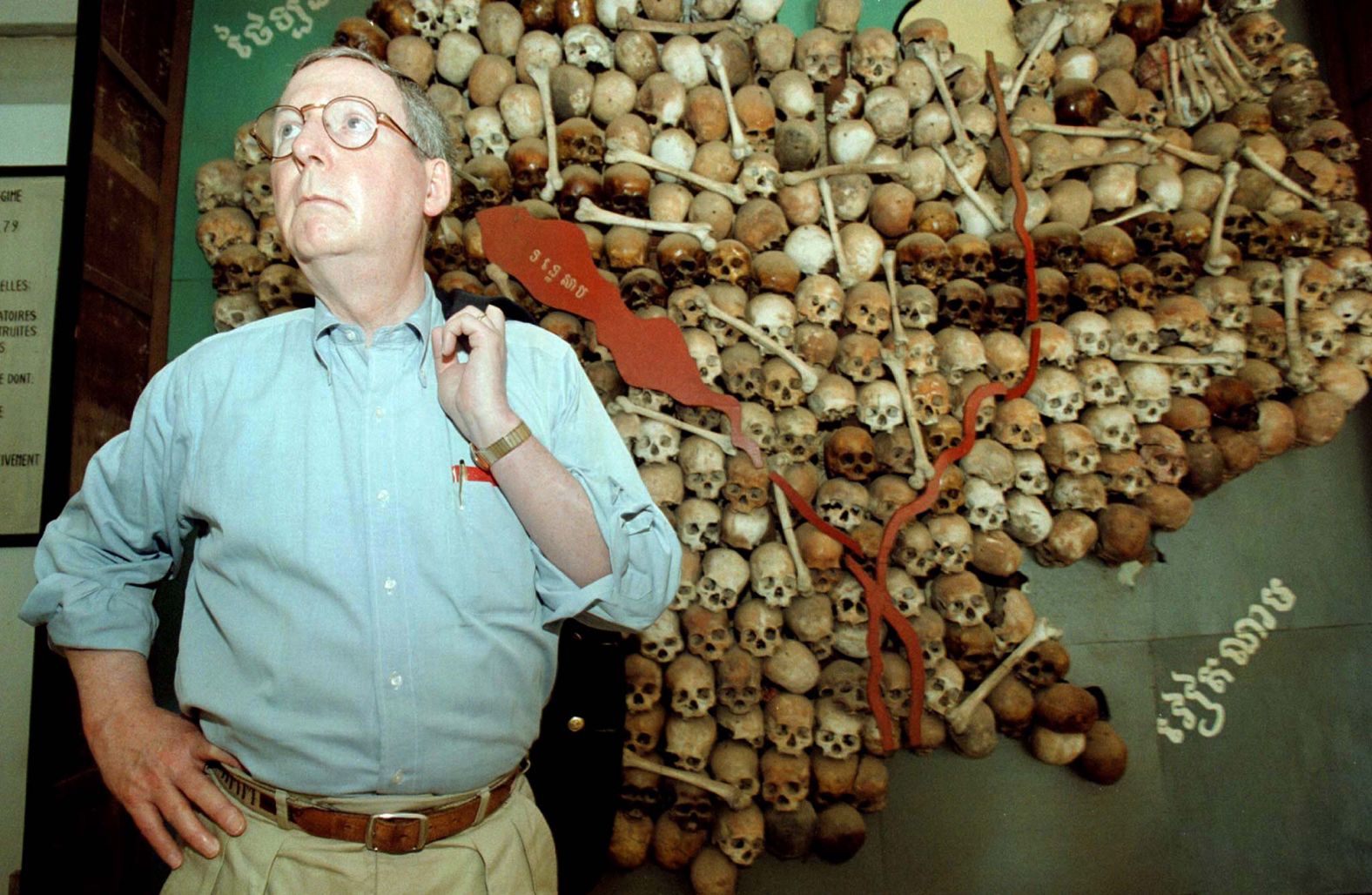 McConnell stands near a map of Cambodia made with the skulls of Khmer Rouge victims during his visit to the Tuol Sleng Genocide Museum in Phnom Penh, Cambodia, in March 1999. McConnell had met with Cambodian Prime Minister Hun Sen and said that US aid would be at risk if a trial of Khmer Rouge leaders did not measure up to international standards.